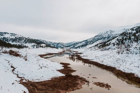Aerial view of snow covered mountain and forest around beautiful lake. Rime ice and hoar frost covering trees, rocks and land near Haim, Konya, Turkeyの写真素材