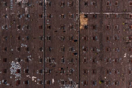 An aerial view of an large industrial factory roof taken with a drone. Abstract striped pattern of windows for backgroundsの写真素材