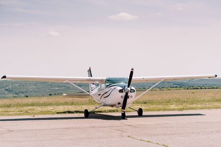 Small propeller sport airplane in the field waiting to take off with sky in background. Private...