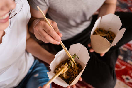Close up couple hands have good time together at home while eating Chinese foodの写真素材