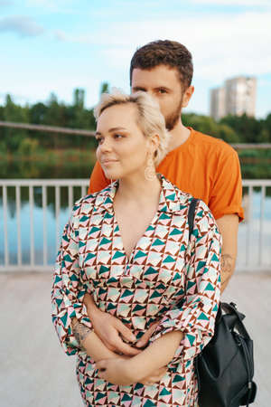 Happy young couple hugging and laughing outdoors.の写真素材