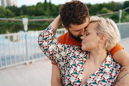 Happy young couple hugging and laughing outdoors.の写真素材