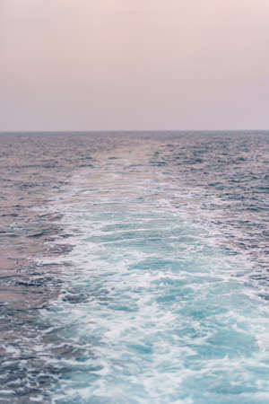 Water surface background. Blue sea water splashes with sun reflections. Ripples of water in the.