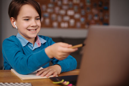 A Preteen boy uses a laptop to make online classes. E-Education Distance Learning, Home Schooling.