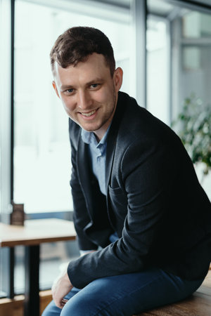 Executive manager portrait looking at camera standing in modern loft space.