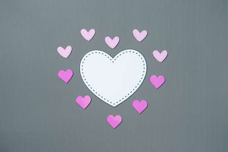 Paper elements in shape of hearts on gray background. Symbols of love for Happy Womens, Mothers,...