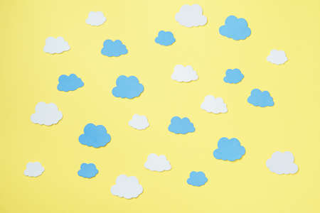 Elements in shape of clouds surrounding yellow background with space for text on orange background. Mockup, copy spaceの写真素材