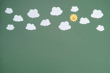 Elements in shape of white clouds on paper green background. Greeting card design. Flat lay. Top viewの写真素材
