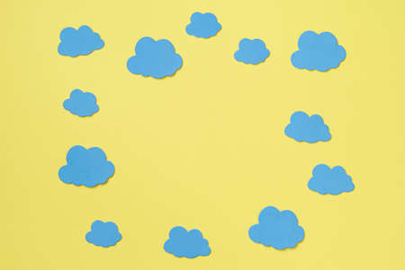 Elements in shape of clouds surrounding yellow background with space for text on orange background. Mockup, copy spaceの写真素材