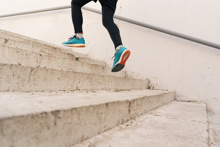 Young man legs running upstairs on city stairs. Fitness, sport, people, exercising and lifestyle conceptの写真素材