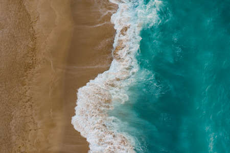 Blue sea wave on sandy beach. Sea shore top viewの写真素材