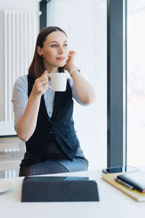 Attractive female with cute smile having a coffee while relaxin in a break