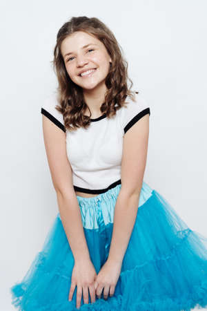 Happy stylish girl teenager posing with penny board on white background. Emotions conceptの写真素材