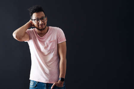 Oops. Sorry. I dont know. Young afro man shrugs, shows helpless gesture, he does not know what to do. Black background with copy space.の写真素材