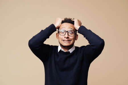 Angry man. Afro man over beige background. Face expression. Crazy man with beard. Negative emotions, problems. Stressed guy wearing glasses.の写真素材