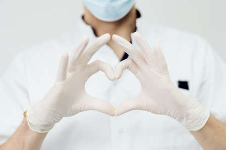 Attractive male doctor show heart sign with hands isolated on white background, model is a caucasian...