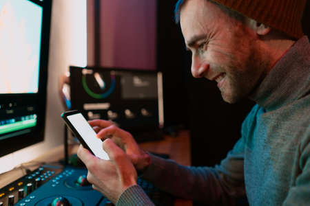 Attractive Male Video Editor Works with Footage or Video on His Personal Computer and having a break...