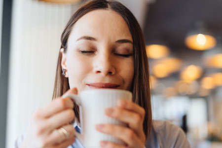 Attractive female with cute smile having a coffee while relaxin in a breakの写真素材