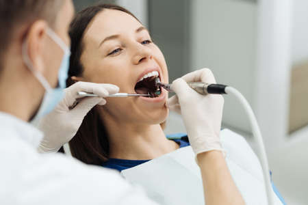 Overview of dental caries prevention. Girl at the dentist chair during a dental scaling procedure. Healthy Smile.の写真素材