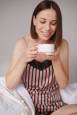 Women enjoying coffee with marshmallows on the bed. Morning surpriseの写真素材