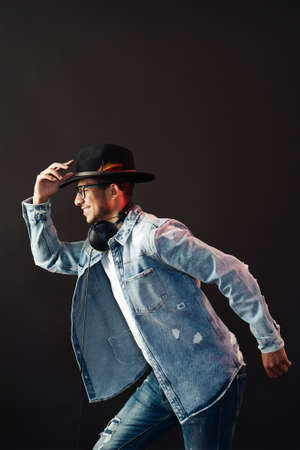 Young African American man portrait wearing headphones and hat and enjoy music over black Backgroundの写真素材