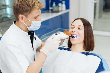 Close-up portrait of a female patient visiting dentist for teeth whitening in clinicの写真素材