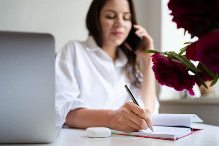 Customer Communications. Home Office Girl Having Phone Conversation With Client Sitting At Laptop In Modern Office. Free Spaceの写真素材
