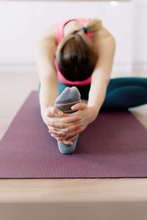 Attractive woman practicing yoga at home using online training instructions
