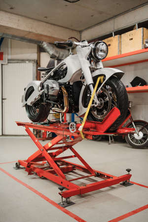 Fixing Custom motorcycle standing in repair shop. Instruments and equipment. Hobbies and unique Jobsの写真素材