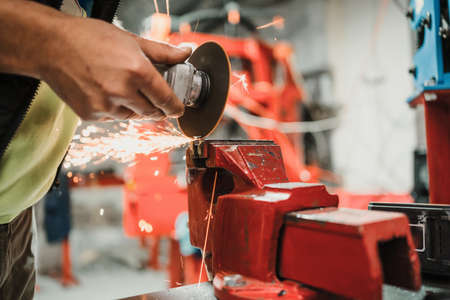 Technician worker cutting metal with many sharp sparks. Using equipments to cat ironの写真素材