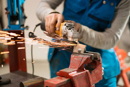 Technician worker cutting metal with many sharp sparks. Using equipments to cat ironの写真素材