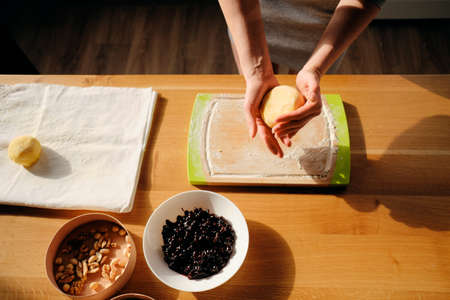 Close up woman hands holding dough, while the sunlight covers her hands