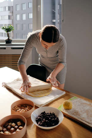 Woman hands preparing dough on a sunny day. Homemade bread, bakery while staying home.の写真素材