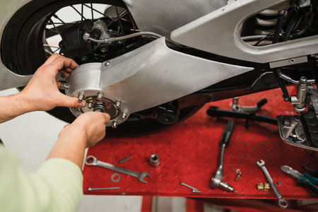 Repairman repair motorcycle, maintenance in garage. Mechanic fixing bike in a modern shop
