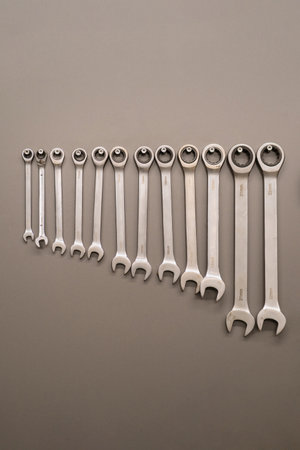 Many wrenches. Grey background. Set of wrenches in different sizes on grey background. Close up.