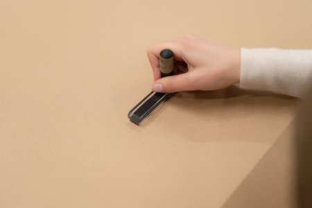 Woman hands placing a stamp on a present box while working in the shop. Prepare order for delivery