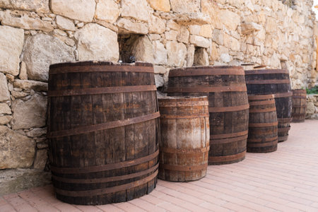 Old wooden barrels on stones wall texture backgroundの写真素材