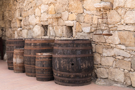 Old wooden barrels on stones wall texture backgroundの写真素材