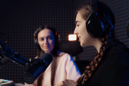 Women speaking during radio program in studioの写真素材