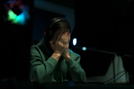 Stressed male cybersport gamer playing video game and praying with hope expressionの写真素材