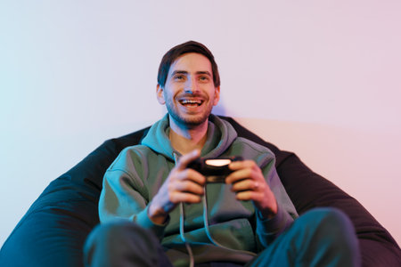 Cheerful male playing video game on consoleの写真素材