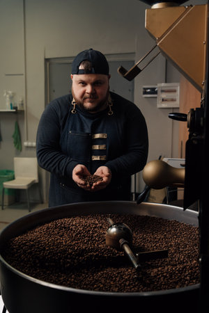 Man smelling coffee beans from cooling trayの写真素材
