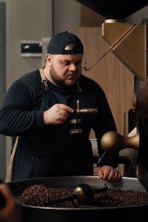 Bearded male worker smelling coffee beans on sample spoon