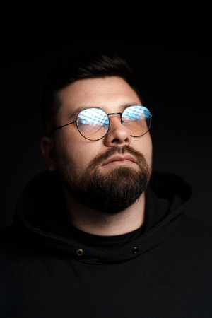 Confident bearded man in eyeglasses on black backgroundの写真素材