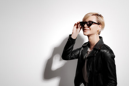 Stylish woman in sunglasses and leather jacketの写真素材
