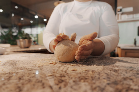 Crop cook kneading dough on counter