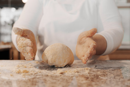 Crop cook kneading dough on counterの写真素材