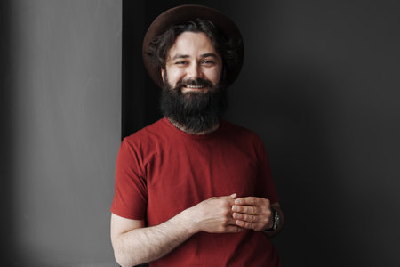 Smiling man wearing black hat and red t-shirt