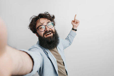 Man taking selfie against grey backgroundの写真素材