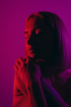 Woman dreaming in studio in neon lightの写真素材
